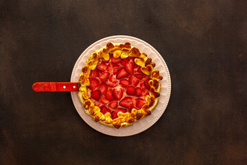 .Beautiful strawberry pie on a plate with a spatula