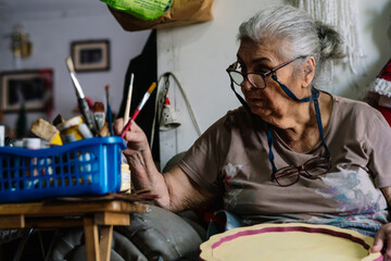 elderly lady choosing brush to paint