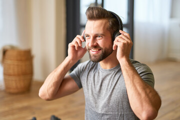 Handsome young man listening to music at home