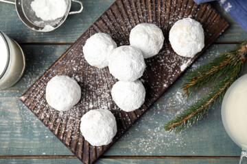 Flat lay composition with tasty Christmas snowball cookies on blue wooden table