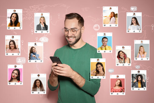 Handsome man visiting online dating site via smartphone on pink background