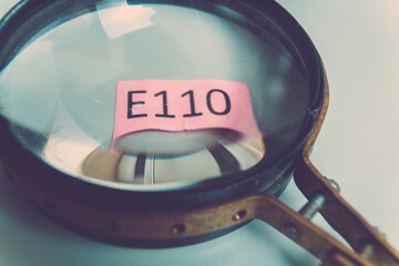 sign with the name of the food additive under a magnifying glass. Unhealthy food concept.