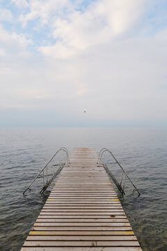 Pontile di legno con scalette su lago di Garda