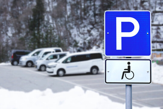 Disabled Parking sign over blurred street city background. 