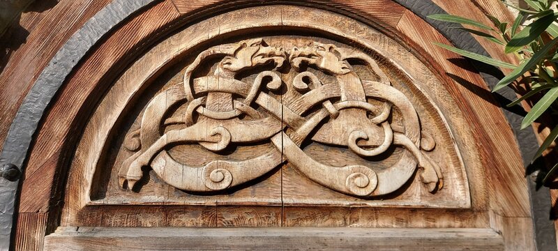 Wooden element of the entrance door with carvings. Interior decor.