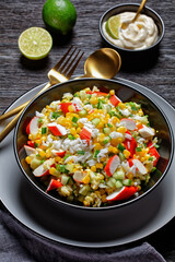 Crab salad on a dark wooden background, top view