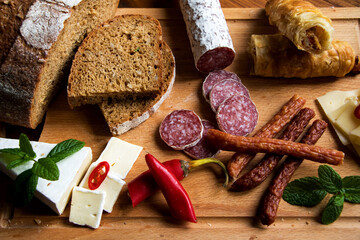 aufschnittplatte mit verschiedenen wurstsorten, brot, käse, peperoni und gefüllten...