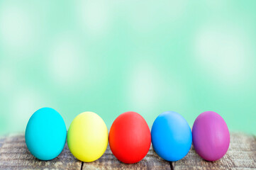 colorful easter eggs on wooden table on green background. copy space