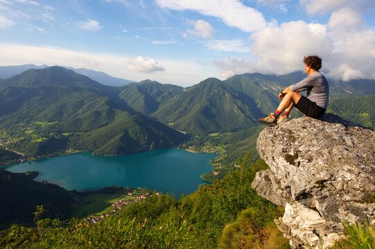 Wanderer am Fels mit Blick zum Ledrosee Italien