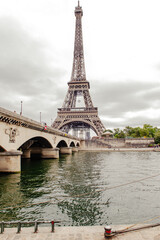 View to the Eiffel tower and bridge over the river in Paris