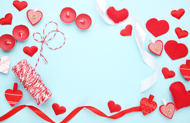 Red hearts with ribbons and candles on blue background