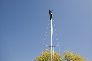 Man hoisted up mast for repairs.