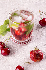 Summer strawberry sweet cherry cocktail ice cold drink in glasses on gray background.