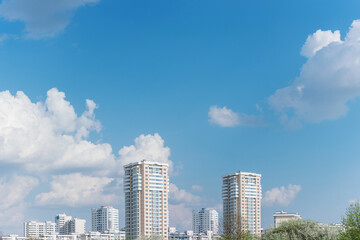 Fototapeta na wymiar Apartment buildings. Blue sky with fluffy clouds, copy space