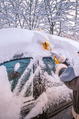 Removing snow from car windshield. Clean car window in winter from snow