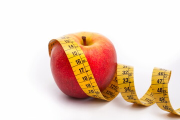 Apple with measuring tape, diet concept. White background