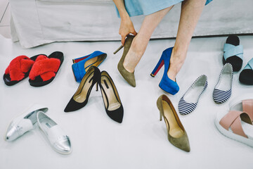 Woman trying on different elegant shoes