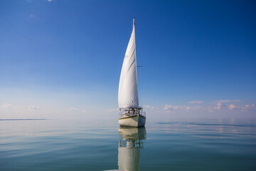 Sailboat calm day with blue sky forward. - obrazy, fototapety, plakaty