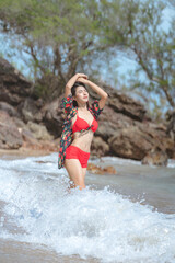 Cute young asian woman in bikini happy on beautiful beach in summer vacation in Thailand