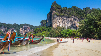 Thai traditional wooden longtail boat on tropical beach with beautiful sand Railay Beach in Krabi province. Ao Nang, Thailand.