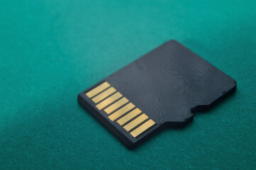 micro sd flash drive lies on a green background. close-up.