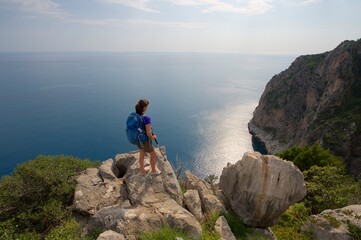 Wanderin auf einem Fels vor Mittelmeer