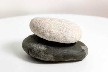Fototapeta na wymiar Two smooth sea stones close-up on a white background.