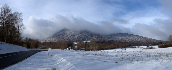 Panoramic view of the snowy Puy-de-Dome, hanging the clouds. Col de Ceyssat, Auvergne
