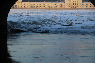 Close-up of the ice hummocks on the river below the fairway bridge on a sunny winter day  © Elena