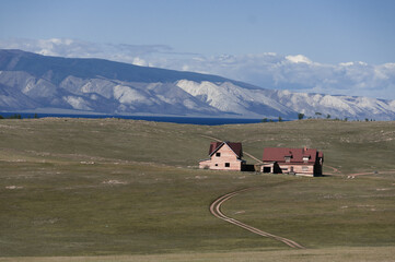 Two wooden houses in the middle of the steppe on the shore of Lake Baikal