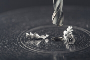 metal drill bit make holes in steel billet with lubricating liquid on industrial drilling machine....