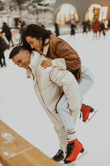 Beautiful Couple In Love. Young couple skating at a public ice skating rink outdoors. Amazing winter holiday. Saint Valentine's Day.