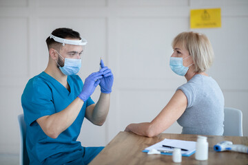 Senior Caucasian woman having covid-19 vaccine injection at hospital. Medical care and health services concept