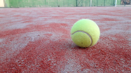 tennis ball on a tennis court ground. Red and green back ground