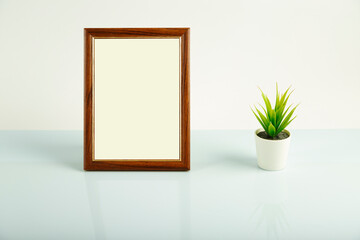 Empty photo frame and flower on the mirror table.Mock up.