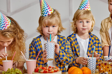 children drinking juice at birthday party, gathered to have fun, enjoy time together, celebrate...