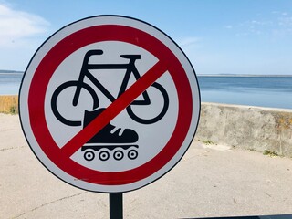 Round white and red sign prohibiting cycling and rollerblading on the waterfront. High quality photo