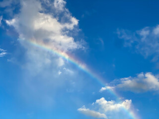 Fototapeta na wymiar Beautiful rainbow with blue cloudy sky over Reunion island