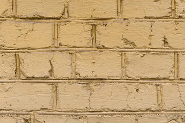 Old scratched brick wall painted with yellow color. Textured background of vintage wall. Panoramic view of empty yellow wall, can be used to interior design. 