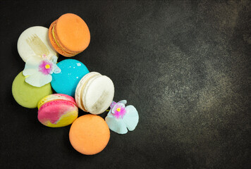 Multicolored macarons on a black background.