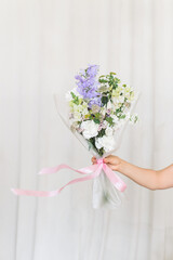 Bouquet with a hand on a white background. The tape is developing.