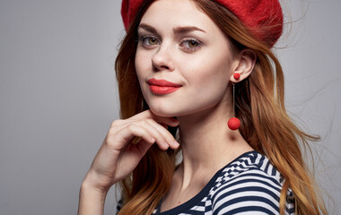 Fototapeta premium Portrait of a romantic woman in a bright makeup beret earrings striped T-shirt