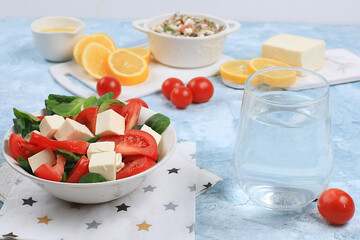 Caprese with mozzarella cheese, cherry tomatoes and fresh arugula, Useful natural breakfast with lemon, detox diet.Traditional Italian food,, cholesterol-free and GMO-free, selective focus