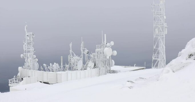 Communication transmitter tower with thick ice layer frost in cold winter storm