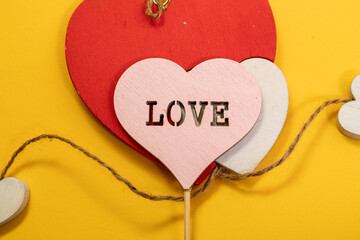 Rustic wooden Valentine red heart on yellow background. Love in wood, valentine day concept.