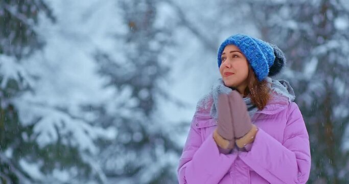 Walk on a frosty winter day, snowfall. Beautiful girl walks under the snow and admires nature, she is happy. 4k, ProRes