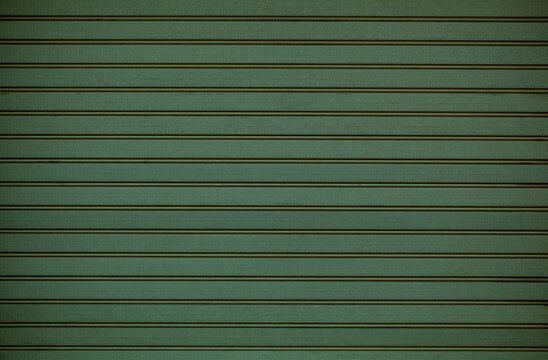 Green wooden wall cladding background texture with repeat pattern of horizontal line in a full frame view. This is a lighter version, a darker version is also available in the portfolio