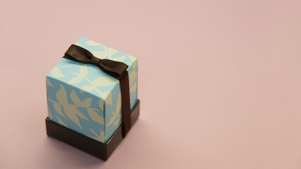 gift in a box with a bow on a pink background
