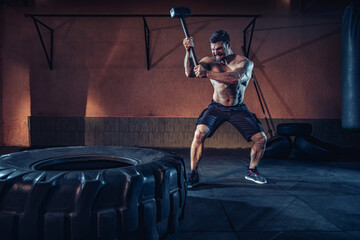 Sports training for endurance, man hits hammer. Concept workout. - Powered by Adobe