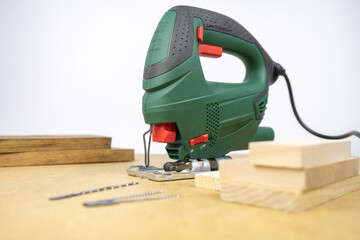Modern electric jig saw tool for DIY home woodworking. Wood boards on background